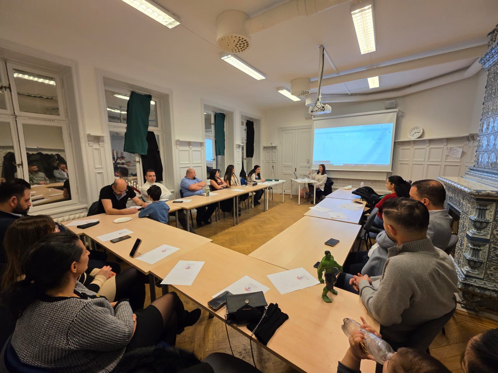 Föräldrar lyssnar på en föreläsning med projektorbild